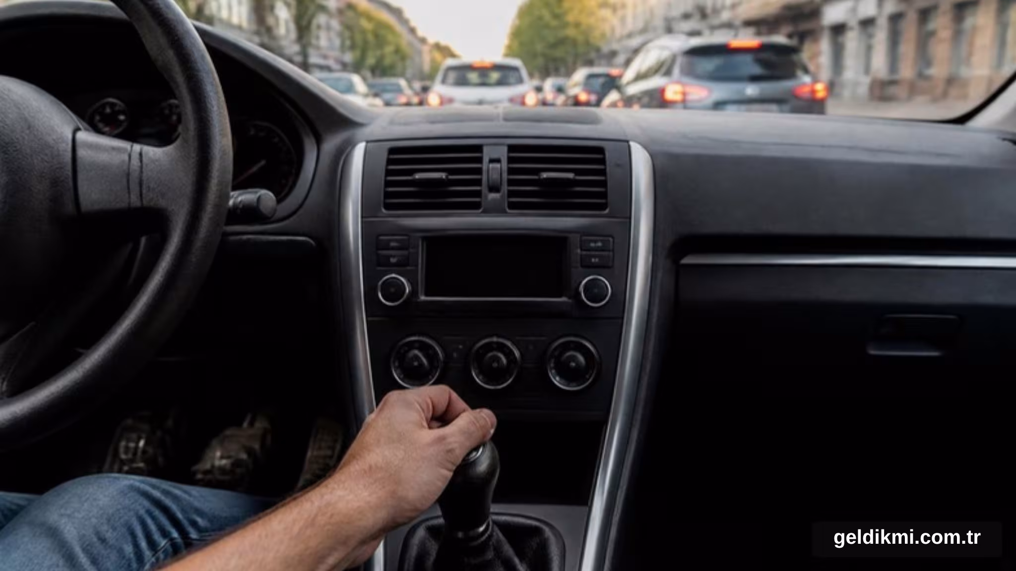 Şehir trafiğinde manuel vites kolunu tutan sürücü eli